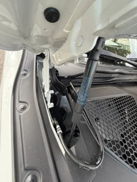 BMW 218 — Петля капота и газовый упор возле водостока BMW 218: петля капота и газовый упор возле водостока
