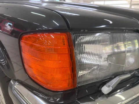 Mercedes-Benz 560 SEL — Передняя фара Mercedes-Benz 560 SEL с оранжевым указателем поворота, вид сбоку Mercedes-Benz 560 SEL: передняя фара Mercedes-Benz 560 SEL с оранжевым указателем поворота, вид сбоку