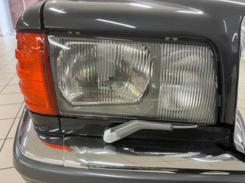 Mercedes-Benz 560 SEL — Крупный план передней фары Bosch Mercedes-Benz 560 SEL и стеклоочистителя фары Mercedes-Benz 560 SEL: крупный план передней фары Bosch Mercedes-Benz 560 SEL и стеклоочистителя фары