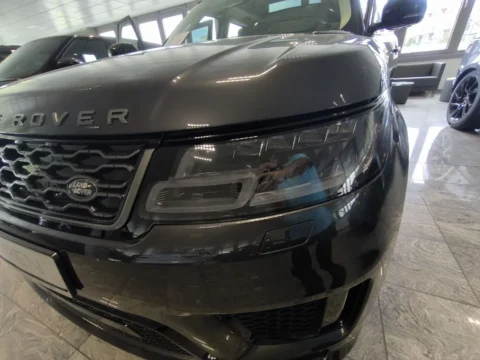 Range Rover Sport — Передняя фара и поверхность капота крупным планом Range Rover Sport: передняя фара и поверхность капота крупным планом